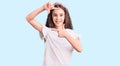Cute hispanic child girl wearing casual white tshirt smiling making frame with hands and fingers with happy face Royalty Free Stock Photo
