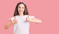 Cute hispanic child girl wearing casual white tshirt success sign doing positive gesture with hand, thumbs up smiling and happy Royalty Free Stock Photo