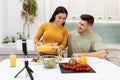 Cute hispanic lovers broadcasting from home, have lunch together Royalty Free Stock Photo