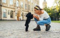 Cute hispanic woman playing with a dog breed toy poodle on the street of the town. A walk with a dog in the park Royalty Free Stock Photo