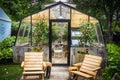 Cute and homey greenhouse used as an outdoor room surrounded by trees and foliage