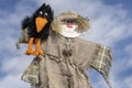 Cute humanoid scarecrow together with a crow on a background of blue sky, Ukraine. Close up Royalty Free Stock Photo