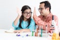 Cute Indian school girl in traditional dress make hi five hand touch during do science experiment in laboratory with father or Royalty Free Stock Photo