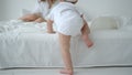 Cute Infant Baby Girl Climbing On The Bed And Crawling To Her Mom Royalty Free Stock Photo