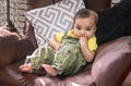 cute infant facial expressing sitting at swing from flat angle indoor shot