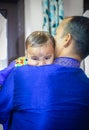 cute infant facial expression resting at father shoulder from flat angle