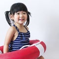 Cute and innocent asian kid with life ring on white backgroun