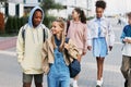 Cute intercultural school learners with backpacks chatting on their way home