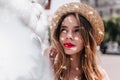 Cute interested girl standing in shadows and looking up. Outdoor photo of blithesome european lady