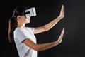 Cute interested woman holding hands up using VR glasses.