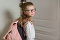 Cute junior schoolgirl with blond hair going to school, standing Royalty Free Stock Photo