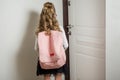 Cute junior schoolgirl with blond hair going to school, standing