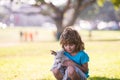 Cute kid boy feels delighted, carries little puppy dog, expresses tender emotions, Child care and love to small doggy