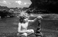 Cute kid boy making stack stones on the coast of the sea in the nature. Cairn on the ocean beach, five pebbles tower Royalty Free Stock Photo