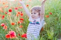 Cute kid boy with poppy flower on poppy field on warm summer day Royalty Free Stock Photo