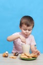 Cute little boy drinking milk on blue background