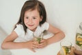 A cute kid drinks homemade lemonade. Healthy lemonade with lemon and lime. Summer cooling drink for children.