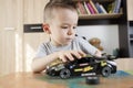 Cute kid focused on assembling toy car