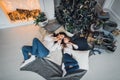 Cute kid girl and her mom playing under christmas tree with presents, lying on wooden floor in room. Wearing trendy Royalty Free Stock Photo