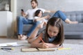 Cute kid girl playing on floor, preschool little girl drawing with colored pencils on paper spending time with family