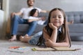 Cute kid girl playing on floor, preschool little girl drawing with colored pencils on paper spending time with family Royalty Free Stock Photo