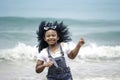 Cute kid having fun on sandy summer beach with blue sea, happy child girl running and playing on tropical beach Royalty Free Stock Photo
