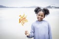 Cute kid having fun on sandy summer with blue sea, happy child holding paper windmill, girl playing on tropical beach Royalty Free Stock Photo