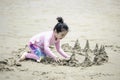 Cute kid having fun on sandy summer with blue sea, happy little girl making sand castle, playing with sandat on tropical beach Royalty Free Stock Photo
