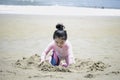 Cute kid having fun on sandy summer with blue sea, happy little girl making sand castle, playing with sandat on tropical beach Royalty Free Stock Photo