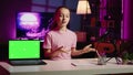 Cute kid in home studio presenting advertisement from sponsoring brand on green screen laptop