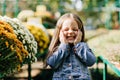 Cute kid laughing on blur nature background. Outdoor shot of excited child smiling near flowers Royalty Free Stock Photo