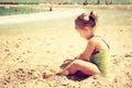 Cute kid playing at the beach. filtered image, retro style