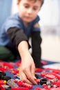 Cute kid playing with plastic blocks