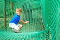 Cute kid plays at outdoors playground. Modern rope adventure park. Happy childhood. Happy summer holidays Royalty Free Stock Photo