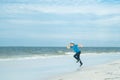 Cute kid run on summer sea. Full body of kid boy running on summer beach. Happy boy enjoys run on ocean. Amazed child Royalty Free Stock Photo