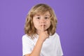 Cute kid with show no talk gesture. Boy with shows shh sign. Be quiet. Hush dont tell. Child put finger to lips mouth