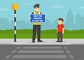 Cute kid is waiting at crosswalk with belisha beacons. Police officer holding `Wait for drivers to give way` warning design poster Royalty Free Stock Photo