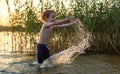 Cute kid in water at sunset lake. Caucasian White boy