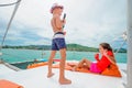 Cute kids on a boat trip. Boy is playing a toy guitar for his be Royalty Free Stock Photo