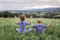 Cute kids, boy and girl, doing the morning exercises on the top of the mountains in summer nature Royalty Free Stock Photo