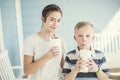 Cute kids drinking milkshakes or flavored drinks together