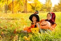 Cute kids in Halloween costumes sitting on grass Royalty Free Stock Photo