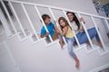 Cute kids, little boy and girl spending time with their young positive mom while sitting together on the stairs at home Royalty Free Stock Photo