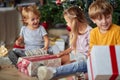 Cute kids opening Christmas gift at home