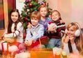 Cute kids sitting near Christmas tree