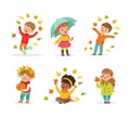 Cute kids in warm clothes walking outdoors in autumn season. Girl and boys standing under umbrella, throwing leaves