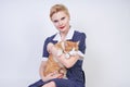 Cute kind woman with short hair in pinup polka dot dress holding her beloved pet on a white background in the Studio. plus size ad Royalty Free Stock Photo