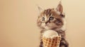 Cute kitten holding an ice cream cone, beige background Royalty Free Stock Photo