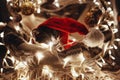 Cute kitty in santa hat sitting in basket with lights and ornaments under christmas tree in festive room. Merry Christmas concept