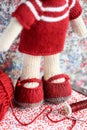 Cute knitted teddy bear toy with knitting tools and wool
